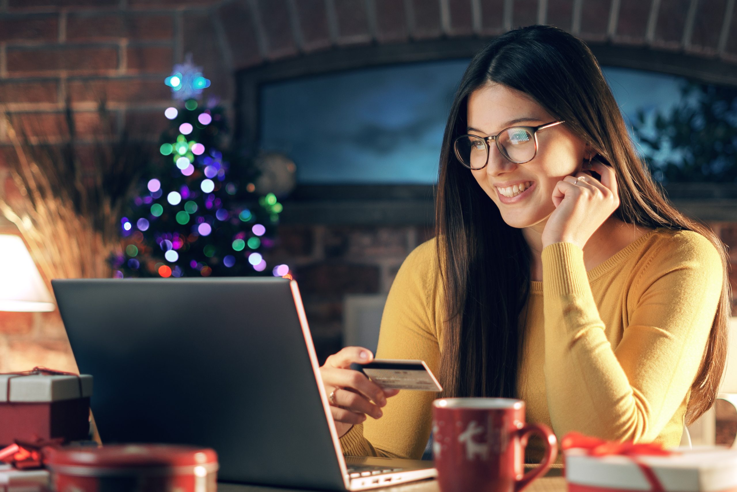 Happy woman buying Christmas gifts online